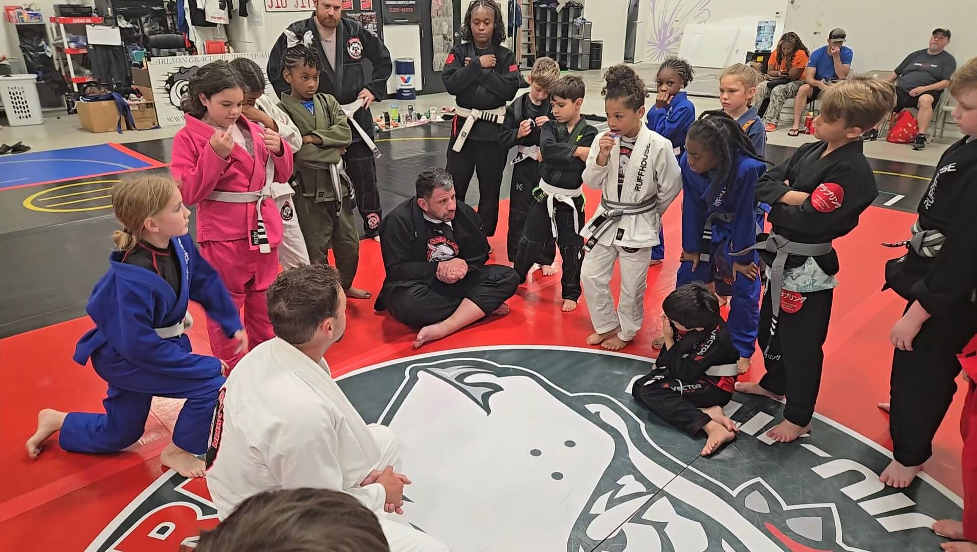 Ruffhouse Jiu-Jitsu young students standing in circle listening to instructor.