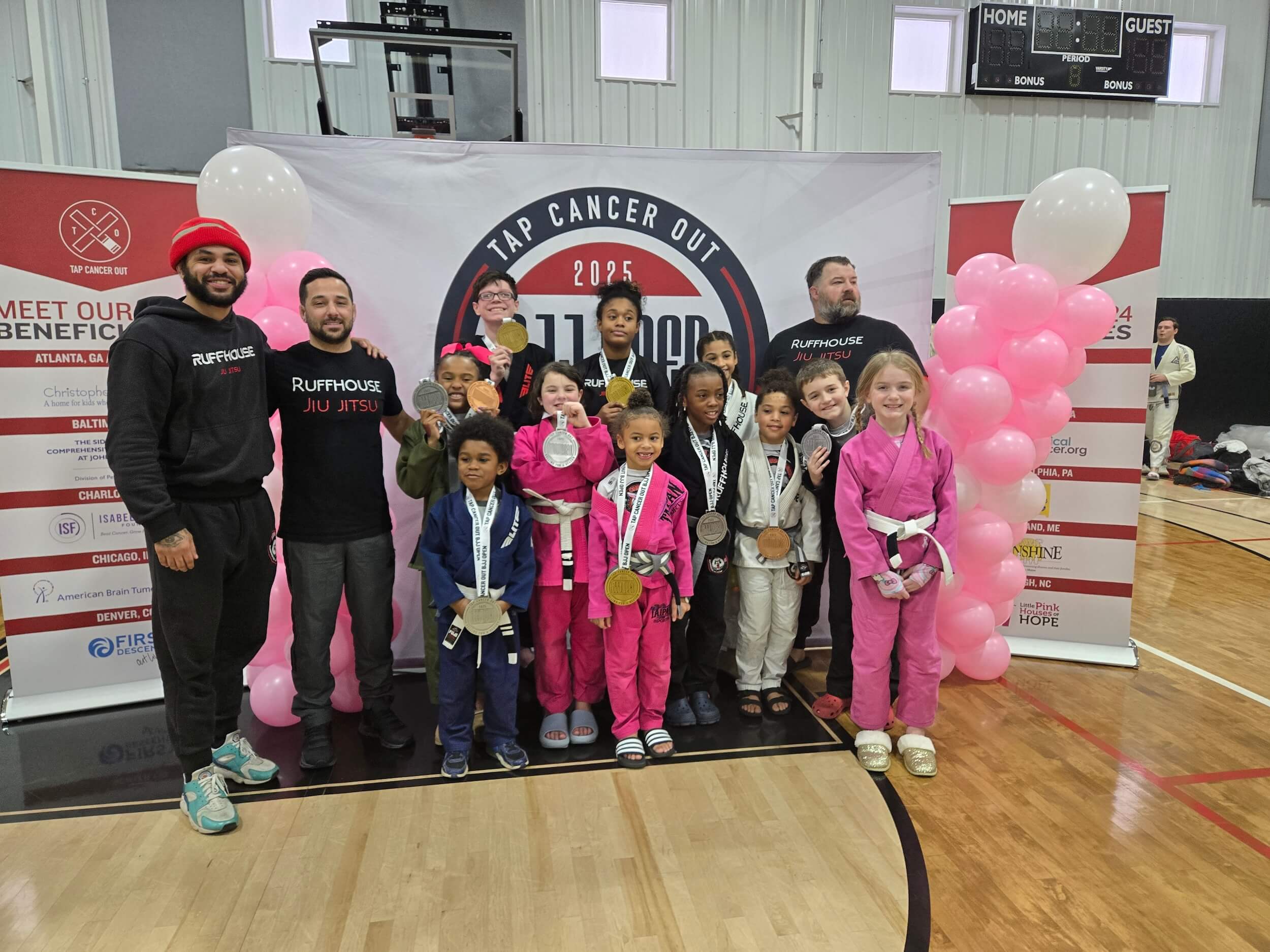 Ruffhouse Jiu-Jitsu young BJJ students smiling wearing gi uniforms at BJJ competition.