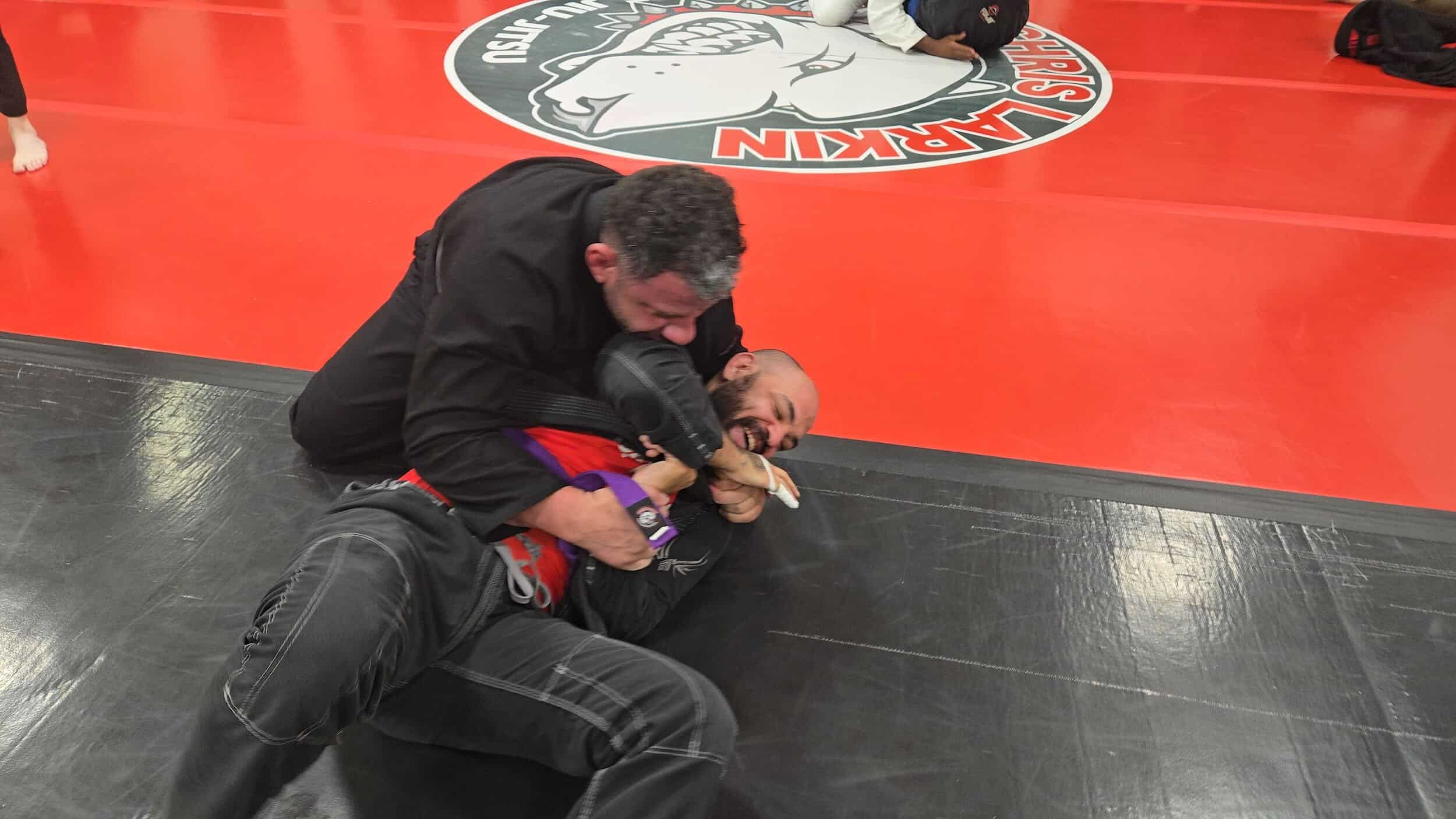Ruffhouse Jiu-Jitsu instructor grappling with student for BJJ technique demonstration.