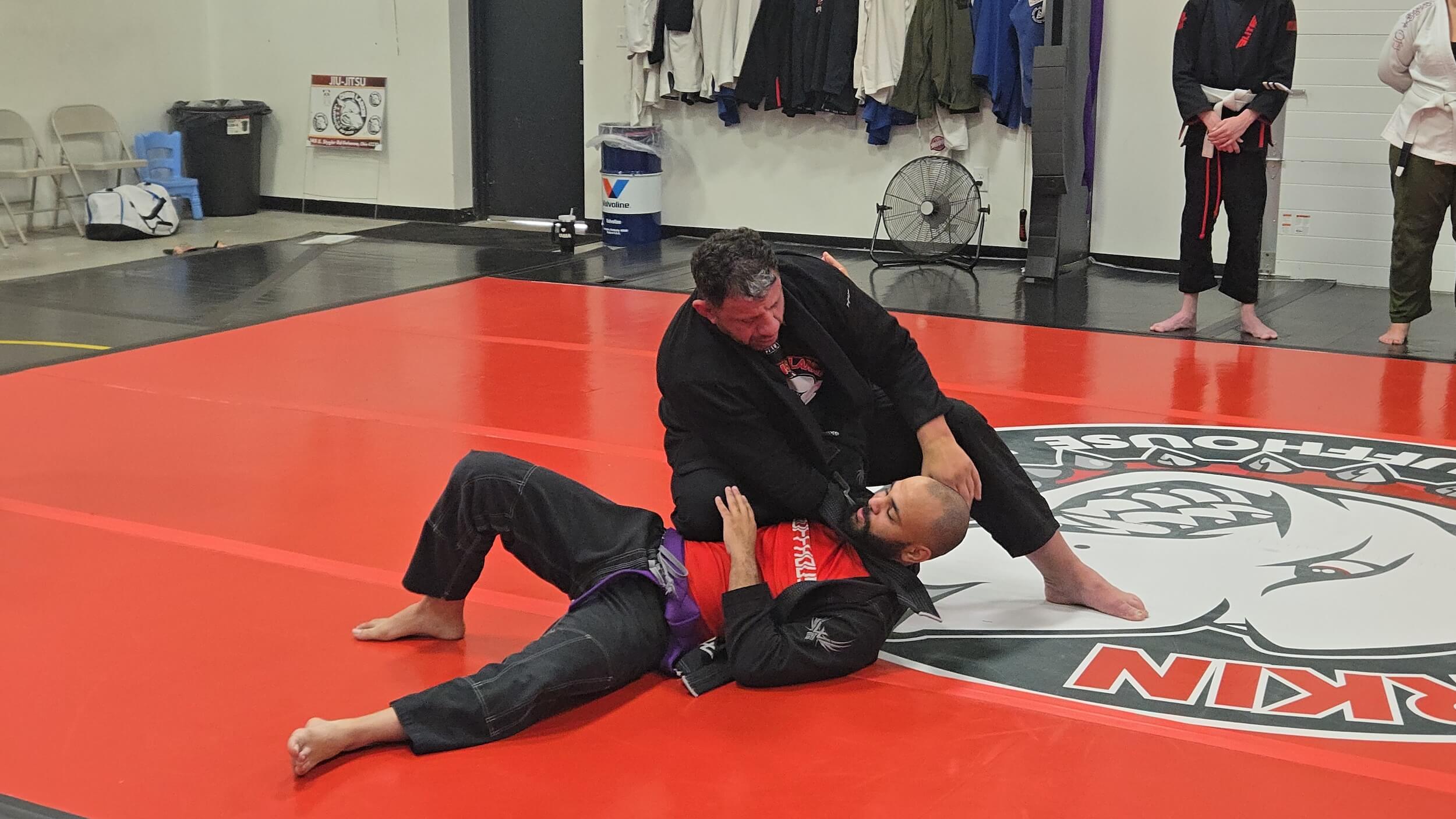 Ruffhouse Jiu-Jitsu instructor grappling with student giving BJJ demonstration.